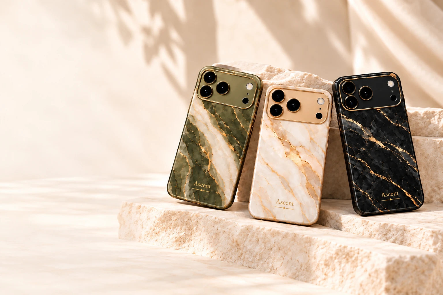 Sage Stone, Gilded Pearl, and Midnight Onyx marble cases on cream stone
